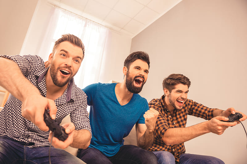 Friends playing football game on couch