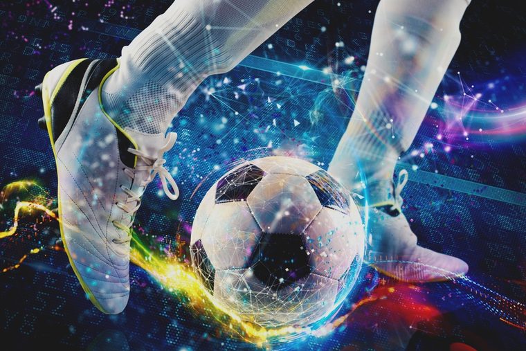 Footballer Kicking Ball Against Digital Background